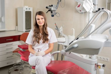 Modern diş hekimi office mikroskobu ile çekici kadın doktor