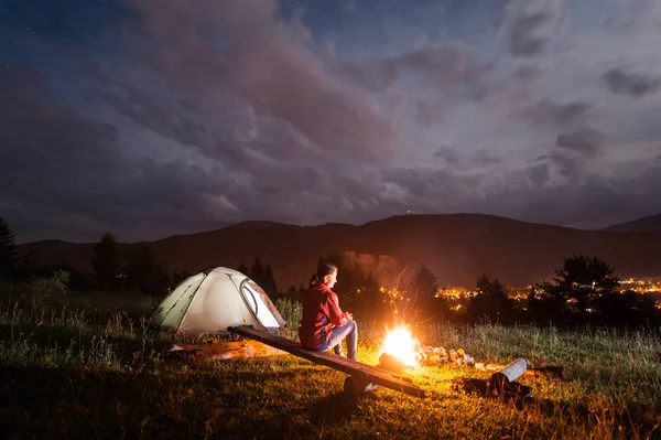 Femme jouissant d'un feu de joie près de la tente sous le ciel nuageux — Photo