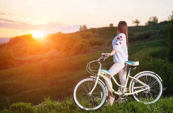 Nő a hegyen, este retro kerékpár — Stock Fotó
