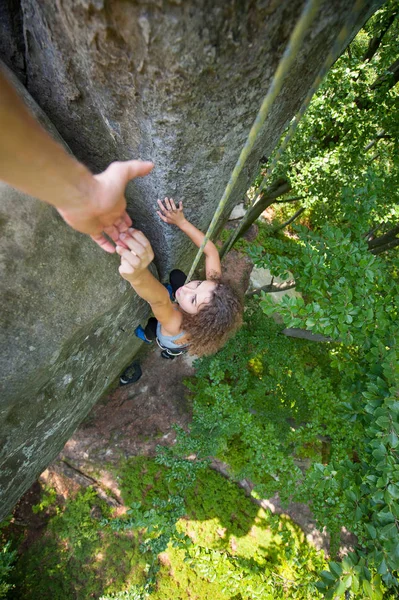 Climber helping female climber to reach a top of mountain — Stock Photo, Image