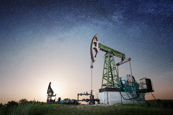 Pompa dell'olio sul campo petrolifero di notte — Foto Stock