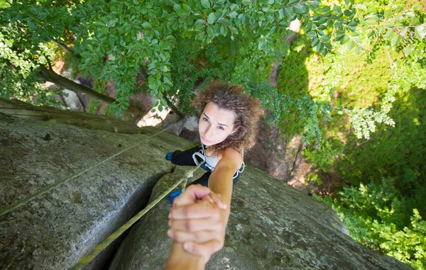 Klimmer helpen vrouw klimmer te bereiken van een piek van de berg — Stockfoto