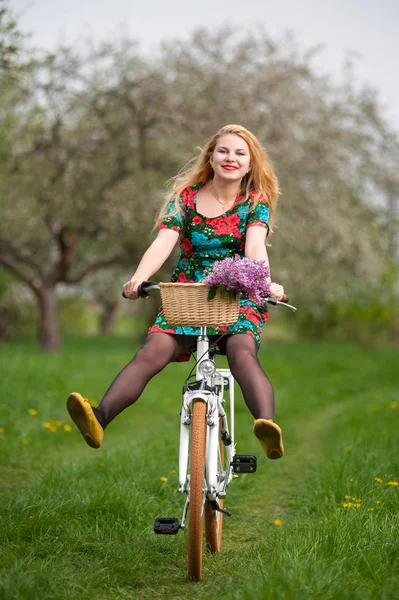 Dziewczyna z rocznika biały rower z koszem kwiatów — Zdjęcie stockowe