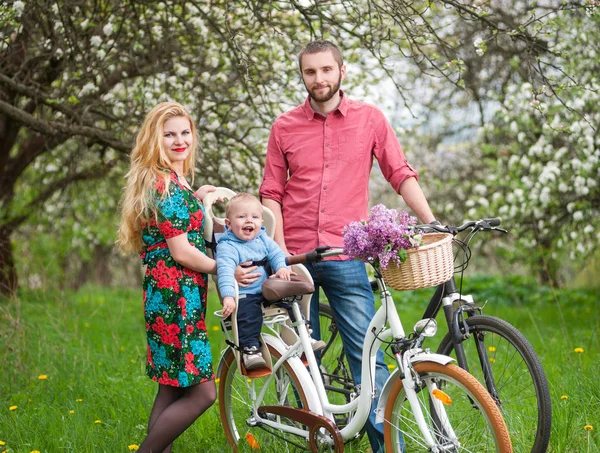 Young family on a bicycles in the spring garden