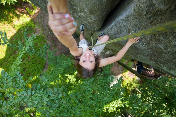 Rockclimber helping to female climber to reach top of mountain — Stock Photo, Image