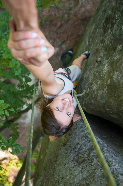 Rockclimber 산의 상단에 도달 여성 산악인에 도움 — 스톡 사진