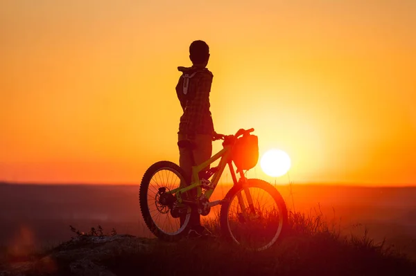 Ciclista con mountain bike in collina la sera — Foto Stock