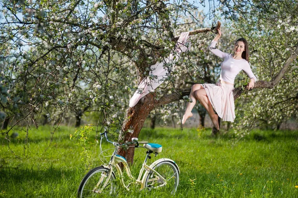 Pięknych kobiet rowerzysta z retro rower w spring garden — Zdjęcie stockowe