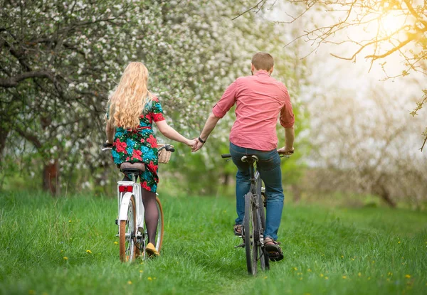 사랑 하는 젊은 부부 봄 정원에서 자전거를 타고 — 스톡 사진