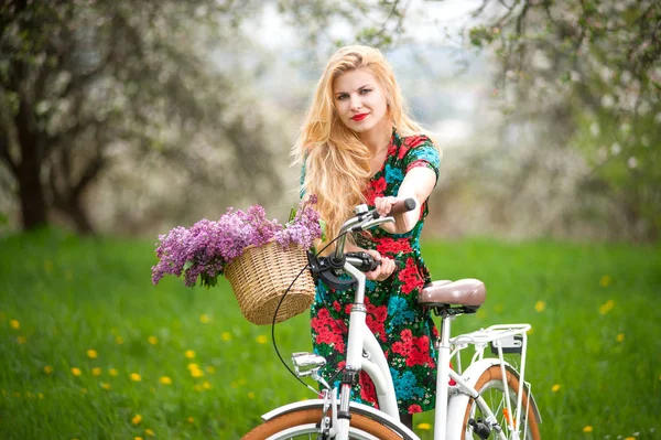 Fille avec vélo blanc vintage avec panier de fleurs — Photo