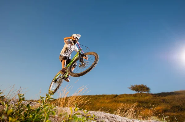 Ciclista montando cuesta abajo en bicicleta de montaña en la colina —  Fotos de Stock