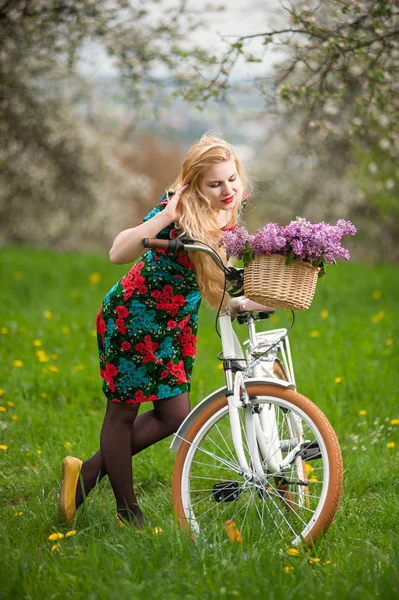 Dziewczyna z rocznika biały rower z koszem kwiatów — Zdjęcie stockowe