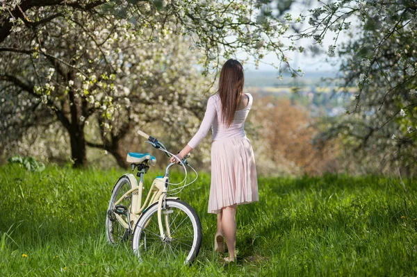 복고풍 자전거 봄 정원에서 아름 다운 여성 사이클 — 스톡 사진