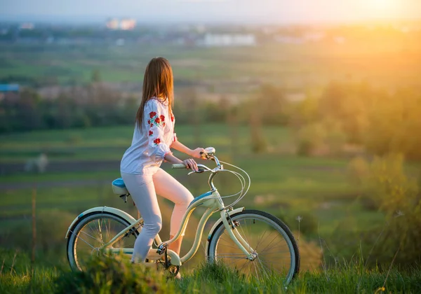 Woman with retro bike on the hill in the evening — Stock Photo, Image