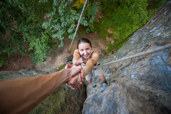 Rockclimber 산의 상단에 도달 여성 산악인에 도움 — 스톡 사진