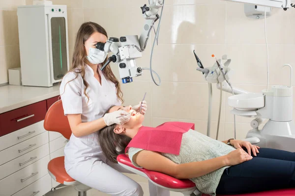 Mujer dentista en su consultorio tratando a mujer paciente —  Fotos de Stock