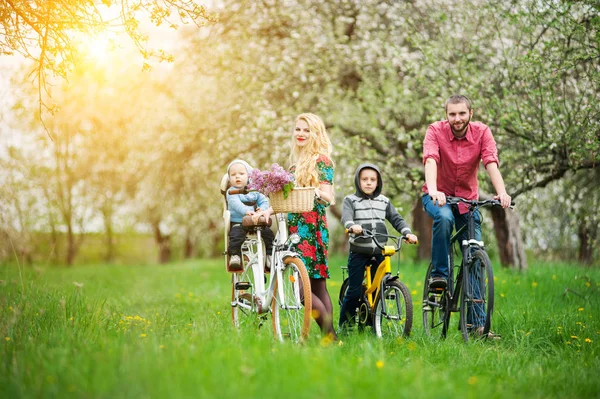 Happy family on a bicycles in the spring garden