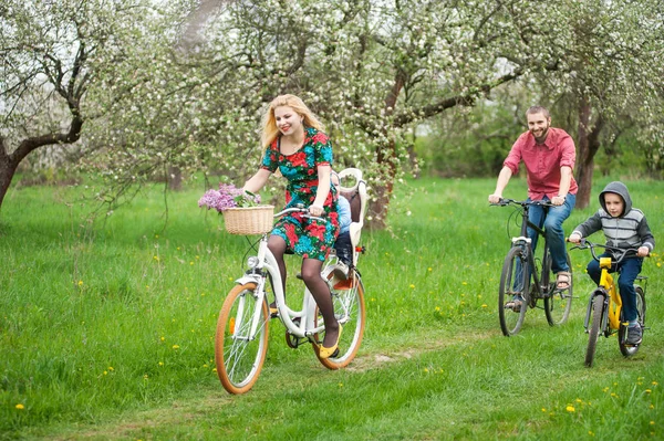 Happy family on a bicycles in the spring garden