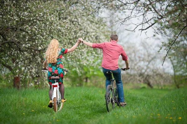 Lief jong koppel paardrijden fietsen in de lentetuin — Stockfoto