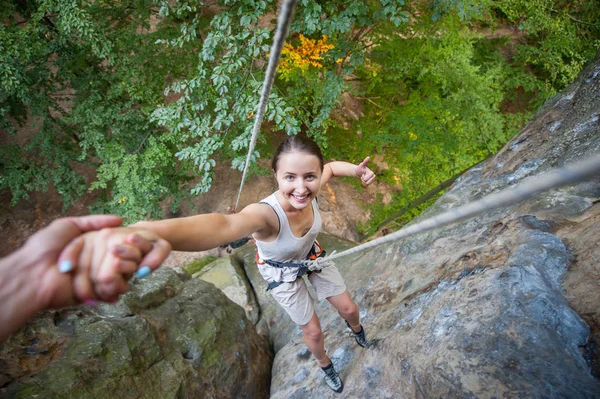 Rockclimber ajudando a alpinista do sexo feminino para chegar ao topo da montanha — Fotografia de Stock