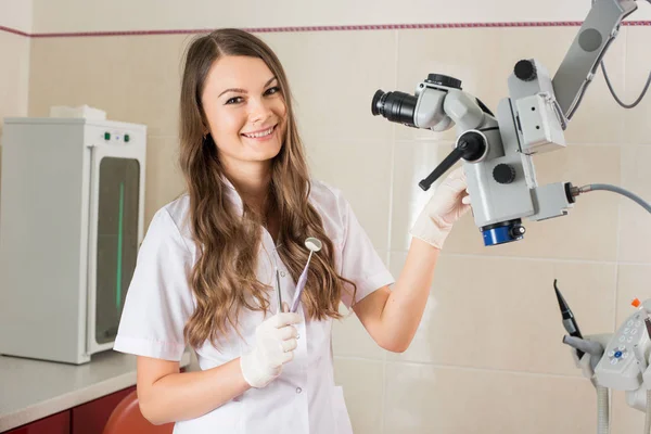 Atraktivní lékařka s mikroskopem v moderní ordinaci — Stock fotografie