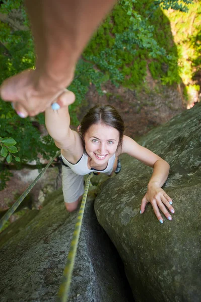 Rockclimber 산의 상단에 도달 여성 산악인에 도움 — 스톡 사진