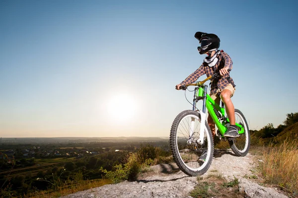 Ciclista con mountain bike sulla collina sotto il cielo blu — Foto Stock