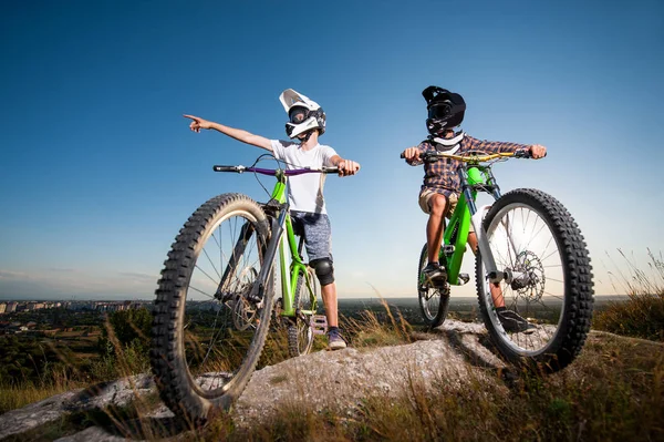 A kerékpárosok és mountain bike a hegyen, kék ég alatt — Stock Fotó