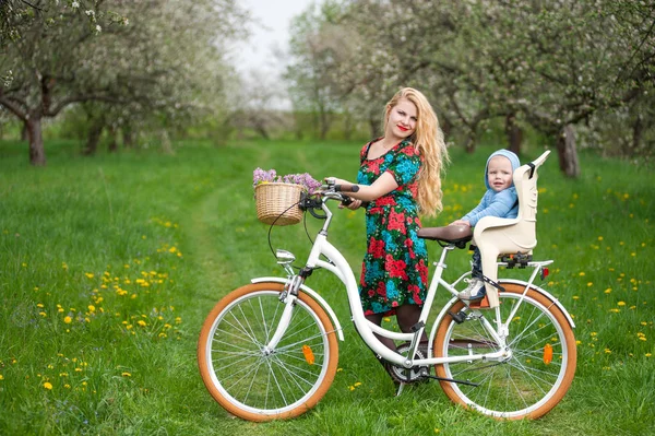 도시 자전거 자전거의 자에 아기와 함께 금발 여성 — 스톡 사진