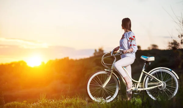 여자는 저녁에 언덕에 복고풍 자전거 — 스톡 사진