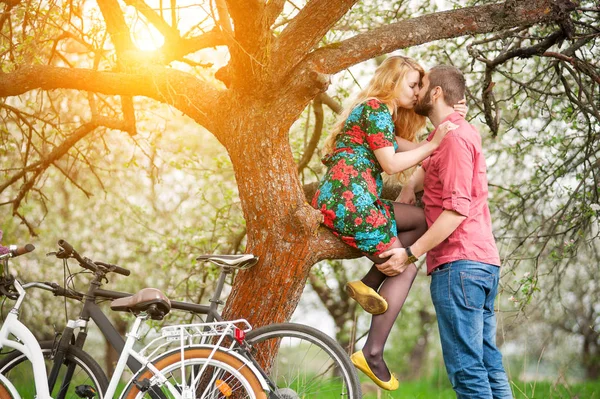 Kochający Młoda para z rowerami w spring garden — Zdjęcie stockowe