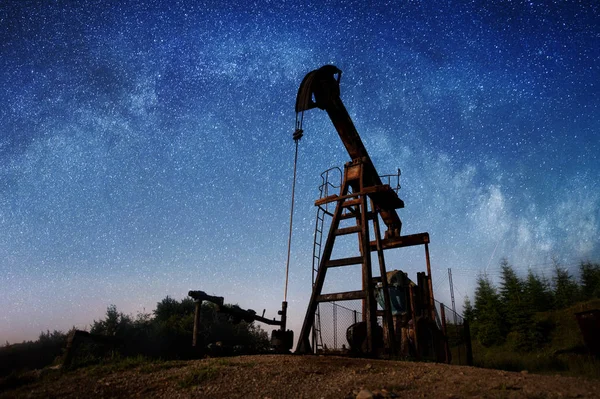 Olaj szivattyú az éjszaka olajmező — Stock Fotó