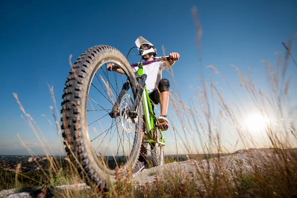 Ciclista com bicicleta de montanha na colina sob o céu azul — Fotografia de Stock