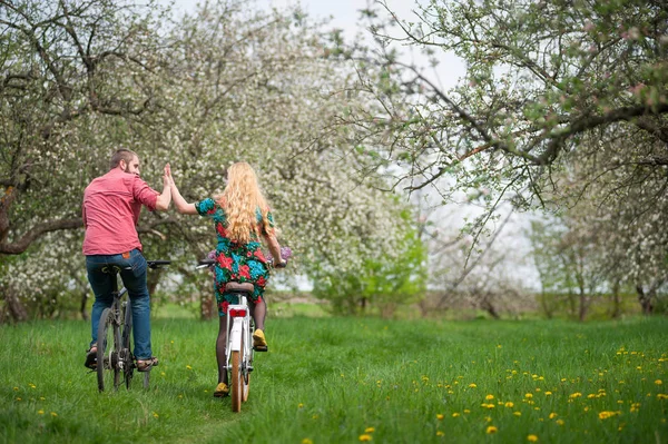 Kochający Młoda para jazdy rowerami w spring garden — Zdjęcie stockowe