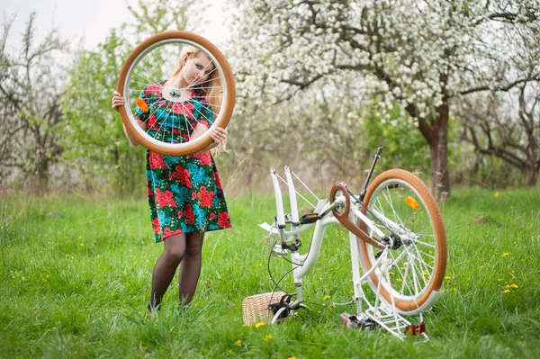 Kvinnlig cyklist med vintage vit cykel i vårträdgård — Stockfoto