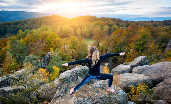 Mujer deportiva en forma está practicando yoga en la cima de la montaña — Foto de Stock