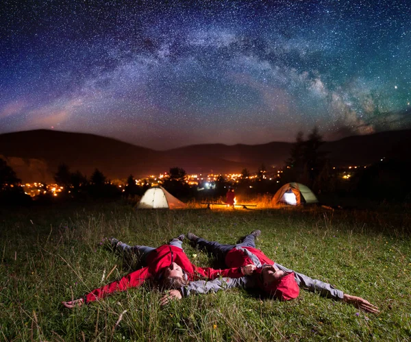 Zwei bewundern die hellen Sterne und liegen auf dem Gras — Stockfoto