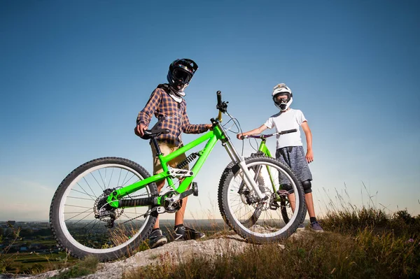 A kerékpárosok és mountain bike a hegyen, kék ég alatt — Stock Fotó