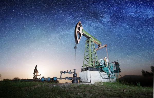 Olejové čerpadlo na ropného pole v noci — Stock fotografie
