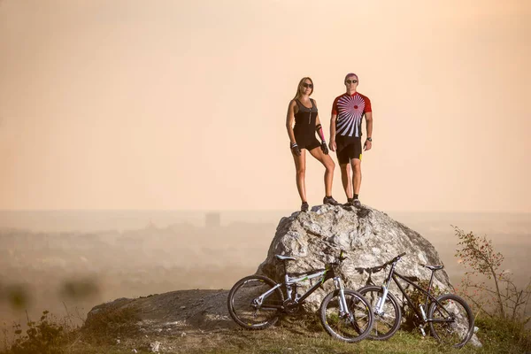 Radfahrer auf einem großen Stein in der Nähe von Mountainbikes — Stockfoto