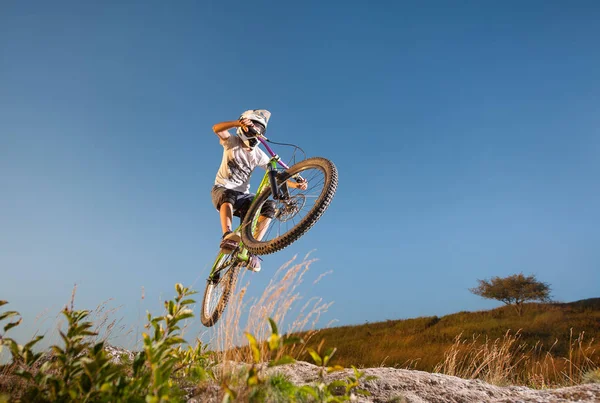 Ciclista in discesa in mountain bike in collina — Foto Stock