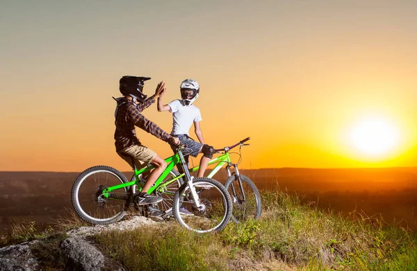 Radfahrer mit Mountainbikes am Abend auf der Schanze — Stockfoto