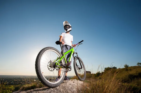 Ciclista con bicicleta de montaña en la colina bajo el cielo azul — Foto de Stock