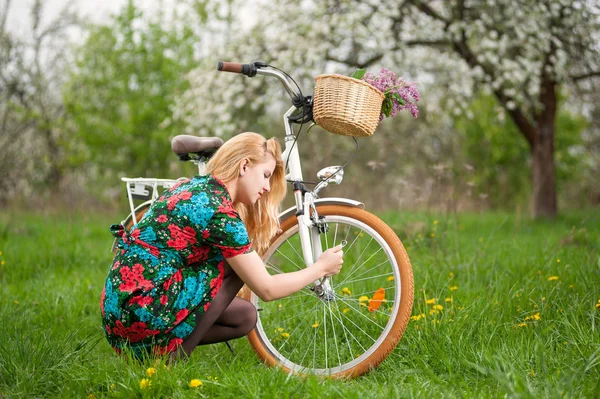 Kobiet rowerzysta z rocznika biały rower w spring garden — Zdjęcie stockowe