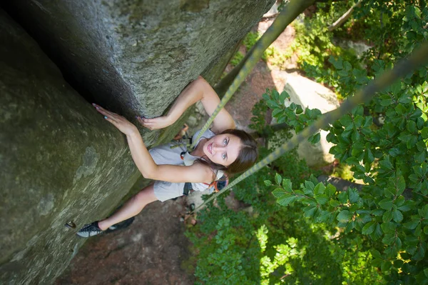Szczęśliwą kobietą, wspinaczka po linie skalną ścianą wspinaczkową — Zdjęcie stockowe