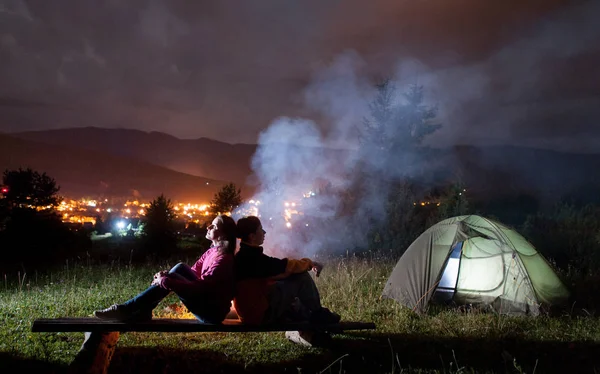 Dois campistas sentados nas traseiras perto da tenda e da fogueira — Fotografia de Stock