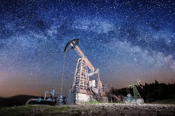 Pompe dell'olio sul giacimento petrolifero di notte — Foto Stock