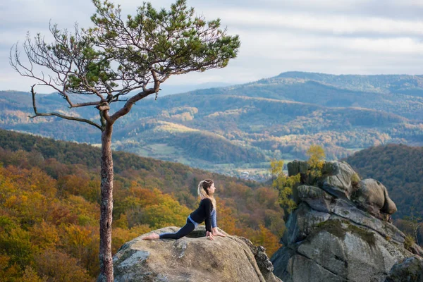 スポーティなフィットの女性が山の頂上にヨガを練習します。 — ストック写真