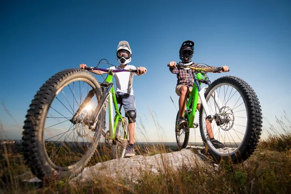 A kerékpárosok és mountain bike a hegyen, kék ég alatt — Stock Fotó
