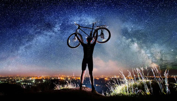 Cyclist with bike in the night under starry sky — Stock Photo, Image